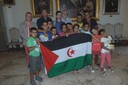 I bambini Saharawi, i loro accompagnatori e in alto, da sinistra, Fabio Campioli (pres. Kabara Lagdaf) e il vicesindaco di Modena Gianpietro Cavazza. Davanti alla bandiera della Repubblica araba democratica Saharawi
