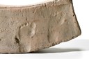 Museo civico: Mattone semicircolare in terracotta dal rivestimento di un pozzo di età romana, con impronta di piedi di bambino